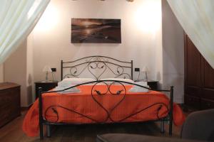 加利亚诺德尔卡波La Casetta di Ciccio的一间卧室配有一张带橙色毯子的床