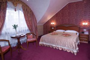 乌日霍罗德Hotel Elefant的一间卧室配有一张大床和一张桌子及椅子