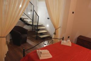 加利亚诺德尔卡波La Casetta di Ciccio的一间卧室设有红色的床和楼梯。