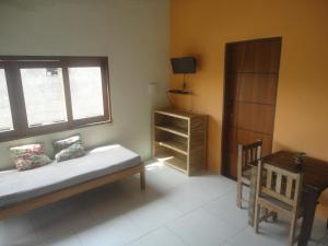 伊塔卡雷Flat Pituba Itacaré的一间卧室配有一张床、一个窗口和一张书桌