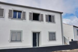 CedrosCasas do Pinheiro的白色的房子,上面有黑色百叶窗