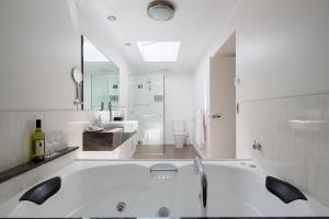 RhyllLuna Blu - Luxury B&B的白色的浴室设有浴缸和水槽。