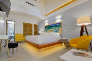 圣安德烈斯帕尔马斯精品酒店的卧室配有一张白色大床和黄色椅子