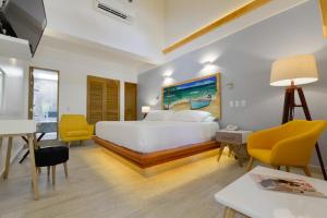 圣安德烈斯帕尔马斯精品酒店的卧室配有白色的床和黄色的椅子