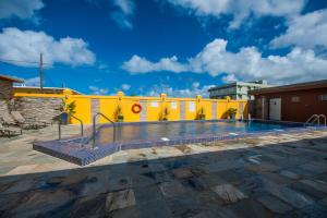 塔穆宁关岛温德姆花园酒店的黄色建筑前的游泳池