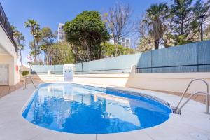 马贝拉Beachfront Apartment Marbella的大楼内的一个蓝色海水游泳池