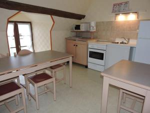 Mareuil-sur-CherLes Berges的厨房配有白色家电和木制桌椅