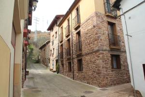仕格莱Apartamentos San Lázaro的老石头建筑中的一条小巷