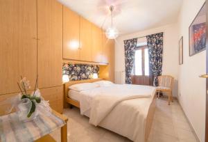 奥斯塔Inn Aosta Apartments的卧室配有一张白色的大床和一张桌子