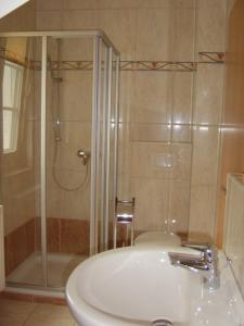 欧巴德伍斯图Aalkoje Ostseebad Wustrow的带淋浴和白色盥洗盆的浴室