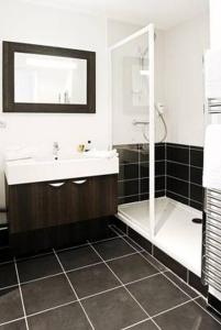 里昂里昂卢米埃拉格朗日公寓式酒店的一间带水槽、淋浴和镜子的浴室