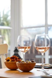 拉尔沃思湾拉尔沃思酒店的两杯葡萄酒和一碗桌上的食物