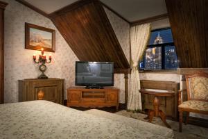 阿斯塔纳精品传统酒店的一间卧室配有电视、一张床和一个窗户。