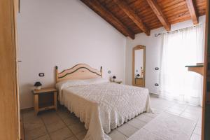 哥斯达雷Sole d'Estate Agriresidence的一间卧室配有一张床、一张桌子和一个窗户。