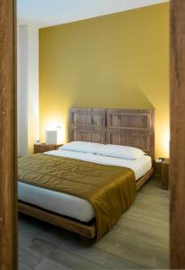 米兰米兰之屋旅馆的一间卧室配有一张大床和木制床头板