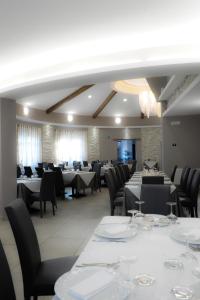 塞拉圣布鲁诺卡拉布里亚公爵酒店的用餐室配有白色桌子和黑色椅子