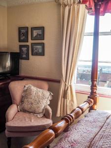 斯卡伯勒高楼酒店的卧室配有床、椅子和窗户。