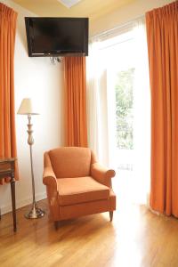 墨西哥城卡萨冈萨雷斯酒店的客厅配有椅子和平面电视