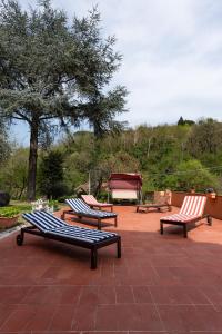 斯培西亚Relais Buonviaggio的三个公园长椅,坐在砖砌的庭院里
