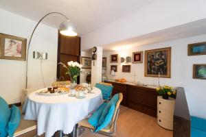 斯培西亚Relais Buonviaggio的一间配备有白色桌子和蓝色椅子的用餐室