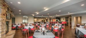 海伦Valhalla Resort Hotel的用餐室配有白色的桌子和红色的椅子
