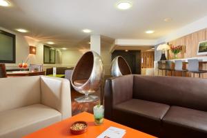 卢尔德罗西酒店的客厅配有两张沙发和一张桌子
