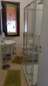 伯吉维奇Casa Vacanze Sottovento的一间带玻璃淋浴和水槽的浴室