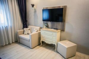 萨尔瓦尔拉文杜拉公寓的一间带椅子和带电视的梳妆台的房间