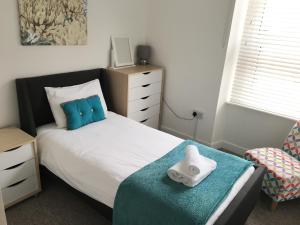 滨海韦斯顿Liberty House的一间卧室配有一张带枕头和椅子的床