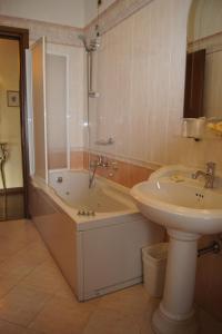 西尔米奥奈路加那帕可阿拉戈酒店的浴室配有盥洗盆、浴缸和盥洗盆