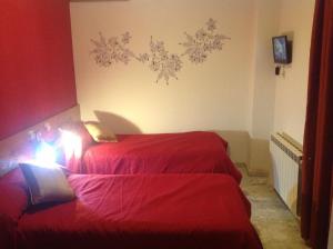 卡塞雷斯海王星旅馆 的小客房内的两张床,配有红色床单