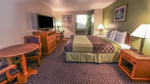 格伦代尔Chariot Inn Glendale - Pasadena的酒店客房设有床、桌子和电视。