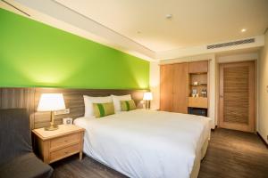 台北洛碁大饭店三贝兹的一间卧室设有一张大床和绿色的墙壁