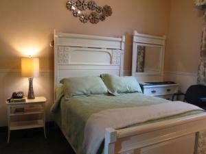 哈利法克斯花园南园酒店的一间卧室配有一张床、一个吊灯和一盏灯。