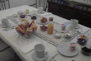 西布勒Chambres d'hôtes Gela Itsasoa Océan的一张带食物盘子的白色桌子和一瓶橙汁