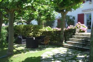 西布勒Chambres d'hôtes GELA ITSASOA Baie的花园设有椅子和粉红色的花卉及树木