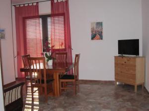 滨海波利尼亚诺Casa Raffaella的一间带桌椅和电视的用餐室