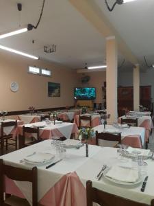 帕利努罗Pensione Nettuno的用餐室配有桌椅和粉红色的桌布