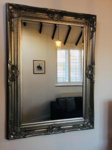 凯尼尔沃思Kenilworth Cosy Garden View Apartment的墙上的华丽镜子