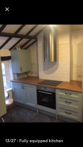 凯尼尔沃思Kenilworth Cosy Garden View Apartment的厨房配有白色橱柜和炉灶烤箱。