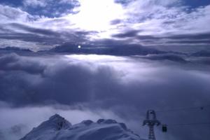 韦尔比耶Hotel Ermitage Verbier的享有带滑雪缆车的雾 ⁇ 覆盖的山脉美景