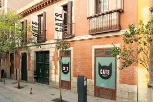 马德里Cats Hostel Madrid Sol的砖砌的建筑,旁边标有猫的标志
