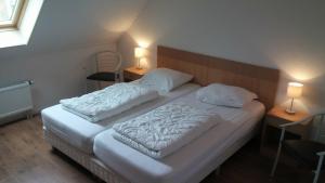比伦Uut in Thuus 21A的一间卧室配有一张带两盏灯的大型白色床。