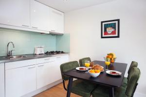 海牙中央车站斯泰西服务式公寓的厨房配有桌椅和食物