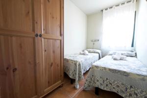 安波拉Clavel的一间卧室设有两张单人床和大窗户