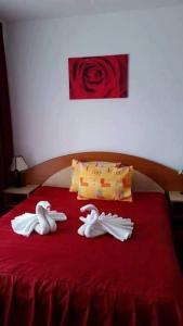 阿拉德Vila Queen的红色床顶上的2条天鹅毛巾