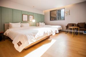 釜山Seomyeon Brown-dot hotel Gold的酒店客房,设有两张床和一张沙发