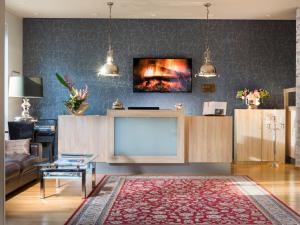 柏林柏林格律瑙大使酒店的客厅配有大电视和沙发