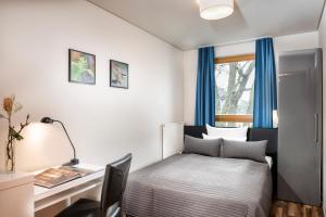 柏林柏林格律瑙大使酒店的一间卧室配有一张床、一张书桌和一个窗户。