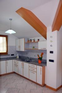 RoncegnoChiara的厨房配有白色橱柜和水槽